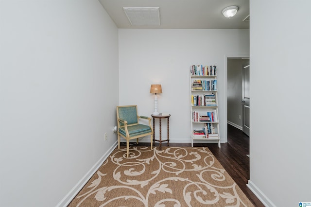 sitting room featuring wood finished floors, visible vents, and baseboards