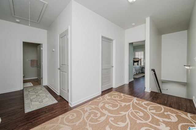 interior space with wood finished floors, attic access, and baseboards