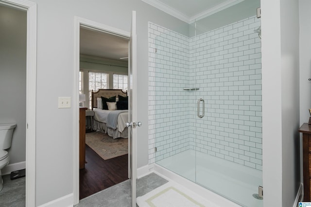 bathroom with a stall shower, baseboards, toilet, ornamental molding, and ensuite bathroom