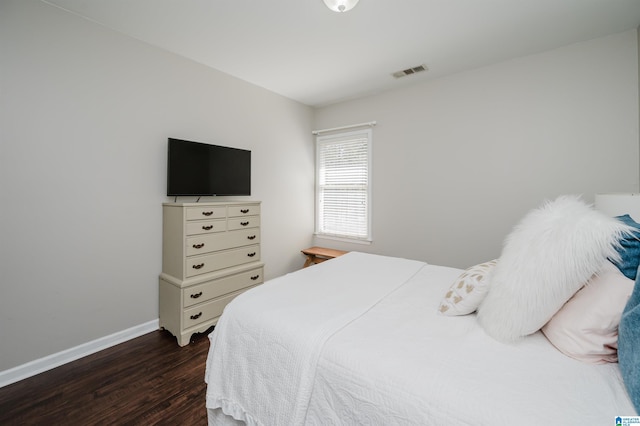 bedroom featuring dark wood-style flooring, visible vents, and baseboards