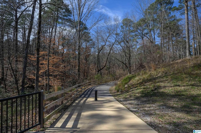 view of property's community featuring fence and a view of trees