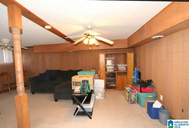 interior space with carpet floors, a ceiling fan, and wooden walls