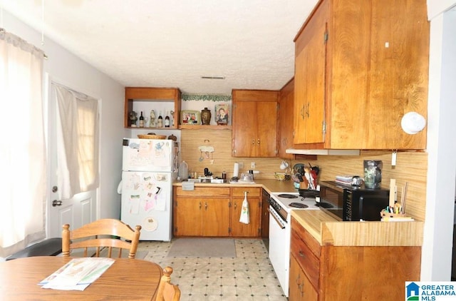 kitchen featuring brown cabinets, white appliances, light countertops, and light floors