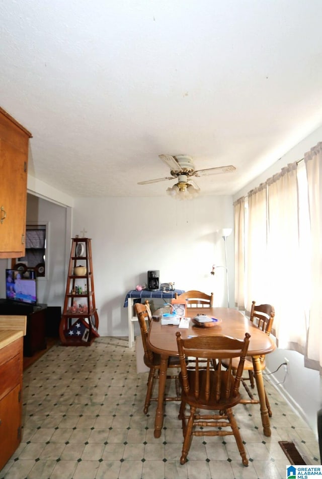 dining space featuring light floors and a ceiling fan