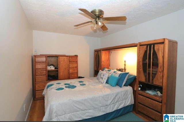 bedroom featuring baseboards, a ceiling fan, and a textured ceiling