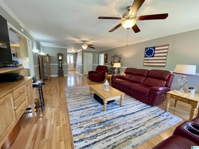 living room featuring ornamental molding, light wood finished floors, and a ceiling fan