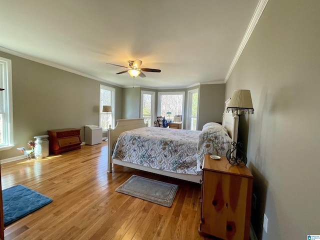 bedroom with ceiling fan, ornamental molding, wood finished floors, and baseboards