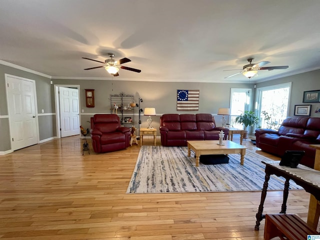 living area featuring ornamental molding, light wood-type flooring, and a ceiling fan