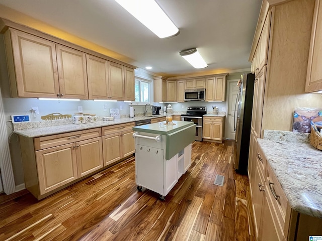 kitchen with visible vents, dark wood finished floors, appliances with stainless steel finishes, light brown cabinets, and a sink