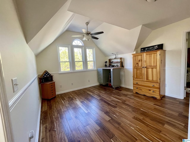 additional living space with lofted ceiling, dark wood-type flooring, a ceiling fan, and baseboards