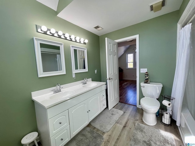 full bathroom with toilet, a sink, and visible vents