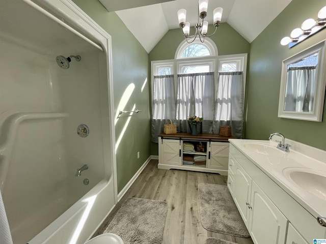 full bathroom featuring lofted ceiling, a chandelier, a sink, and wood finished floors