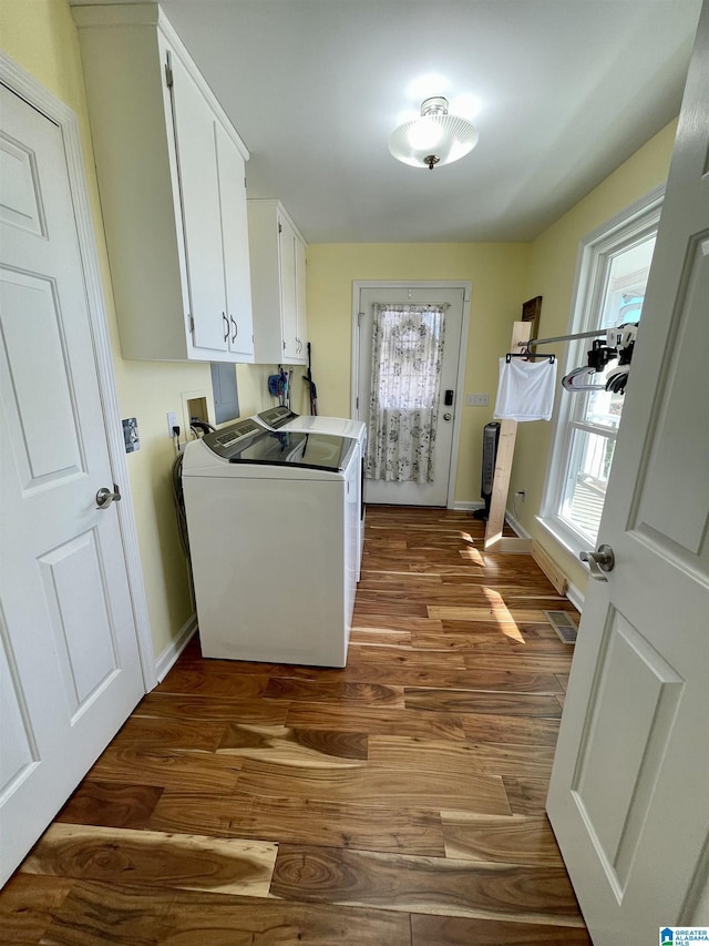 clothes washing area featuring cabinet space, baseboards, dark wood-style floors, and washer and dryer