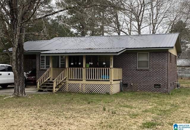 single story home featuring metal roof, a porch, brick siding, crawl space, and a front lawn