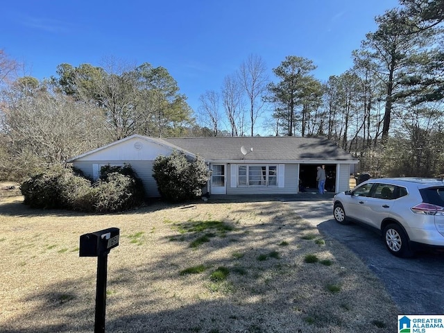 ranch-style house featuring aphalt driveway and a front yard