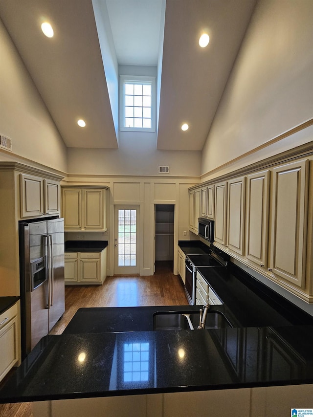 kitchen featuring cream cabinets, recessed lighting, wood finished floors, visible vents, and appliances with stainless steel finishes