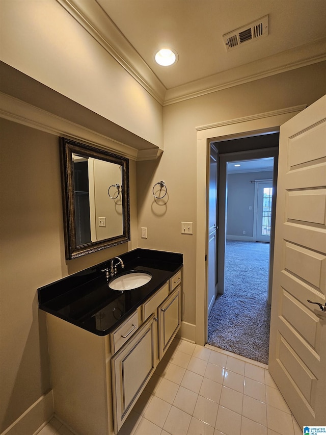 bathroom featuring baseboards, visible vents, ornamental molding, tile patterned floors, and vanity