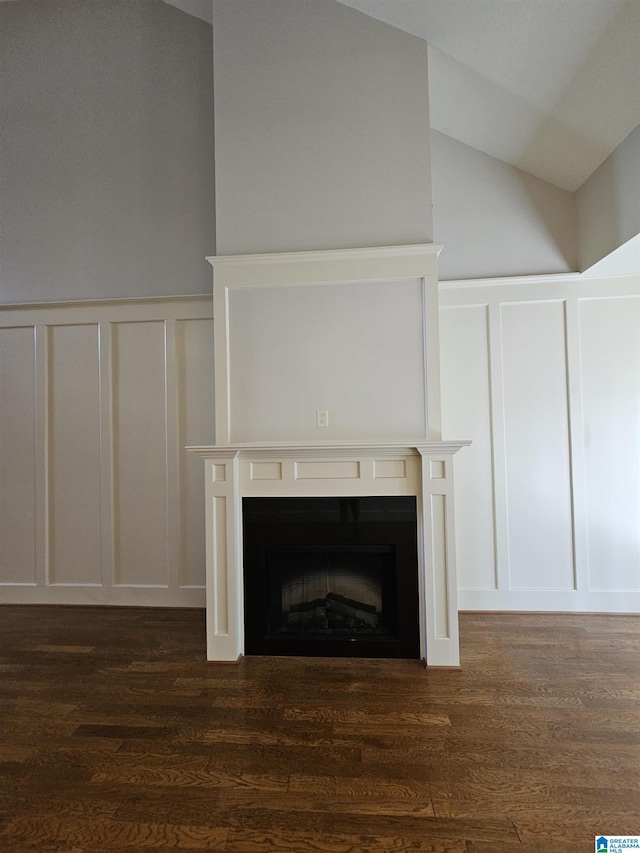 details with a fireplace, a decorative wall, and wood finished floors