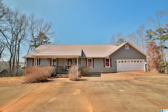 single story home featuring a porch, metal roof, driveway, and an attached garage