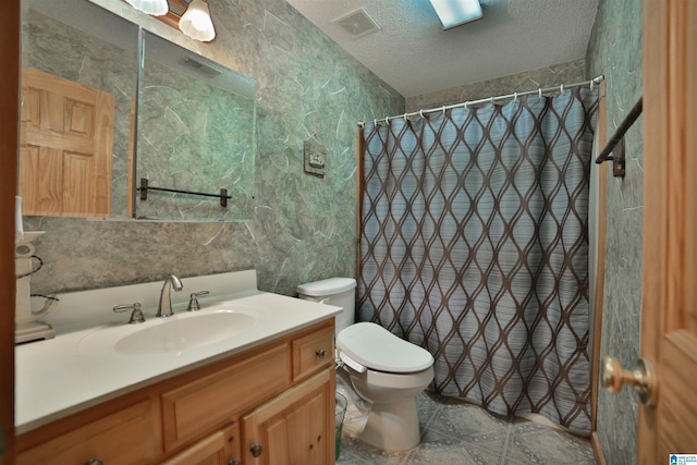 bathroom featuring a textured ceiling, curtained shower, toilet, vanity, and visible vents