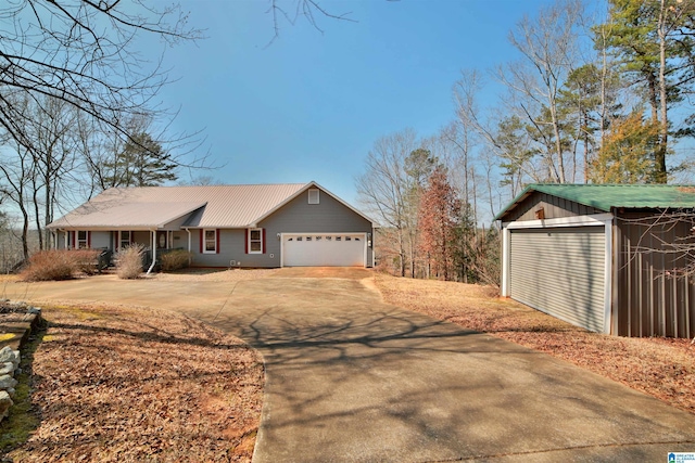 view of front facade with an attached garage, metal roof, and concrete driveway