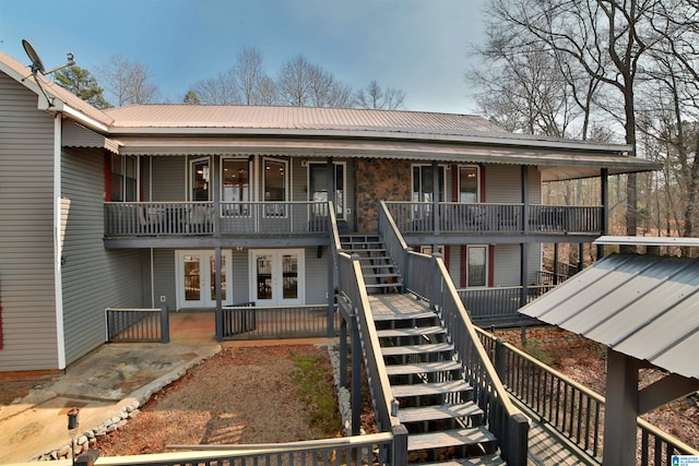 view of front facade featuring french doors, metal roof, and stairway