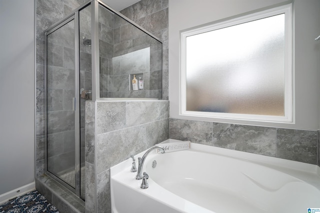 bathroom featuring a shower stall and a bath