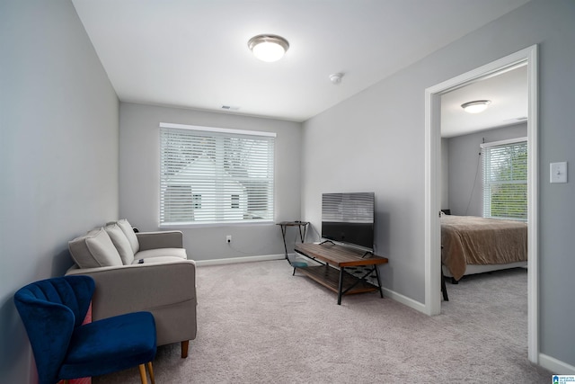 living area with carpet flooring, visible vents, and baseboards