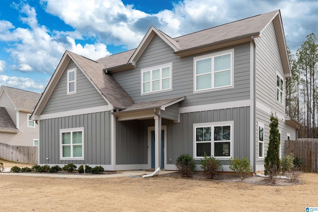 view of front of property featuring board and batten siding, roof with shingles, and fence