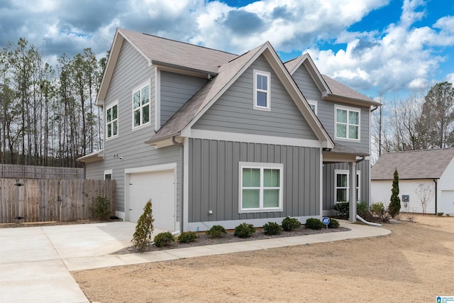 view of front of property featuring driveway, roof with shingles, an attached garage, fence, and board and batten siding