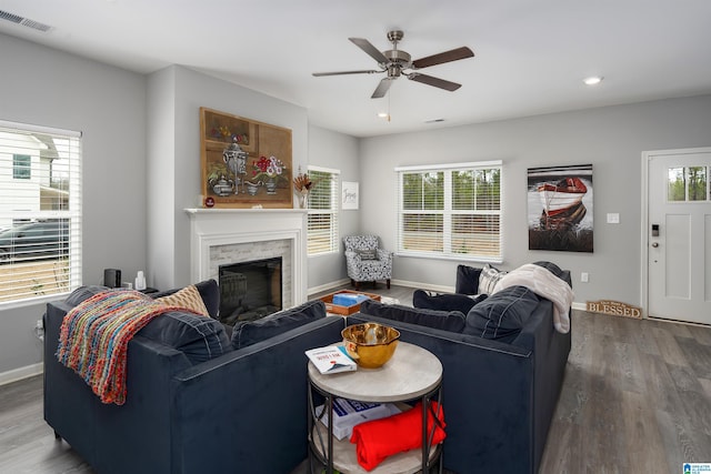 living room featuring baseboards, visible vents, wood finished floors, and recessed lighting