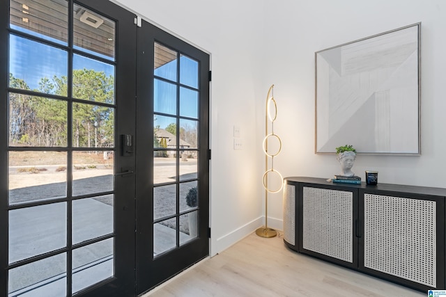 doorway featuring a wealth of natural light, baseboards, wood finished floors, and french doors