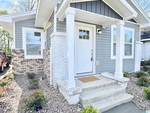 entrance to property featuring board and batten siding and brick siding