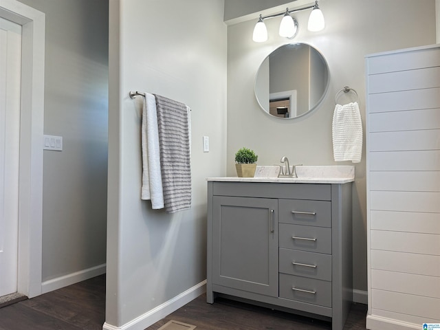 bathroom with baseboards, wood finished floors, and vanity