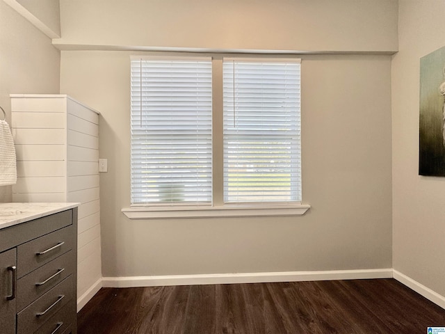 interior space featuring dark wood-style flooring and baseboards