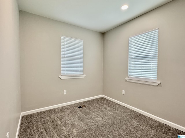 carpeted empty room with visible vents and baseboards