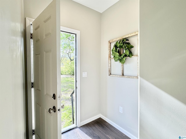 doorway with dark wood-style floors and baseboards