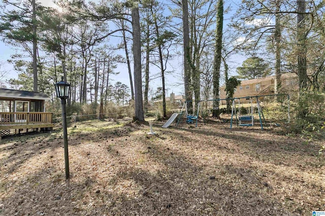 view of yard with a deck and playground community