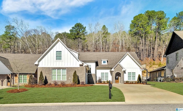 modern inspired farmhouse featuring a front yard, concrete driveway, brick siding, and board and batten siding