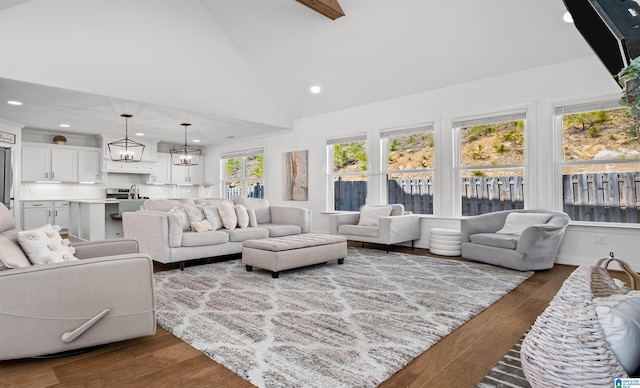 living area with recessed lighting, a notable chandelier, dark wood-style floors, and high vaulted ceiling