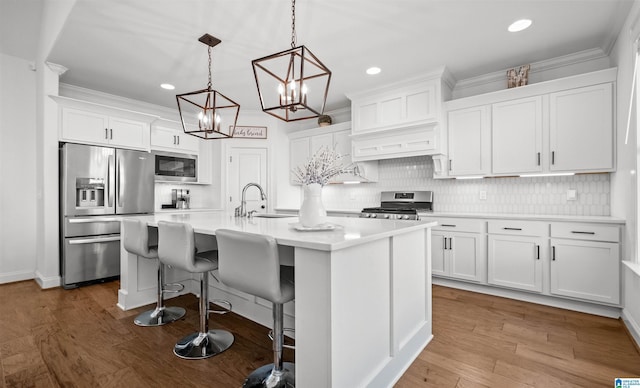 kitchen with white cabinetry, stainless steel appliances, an island with sink, and a sink