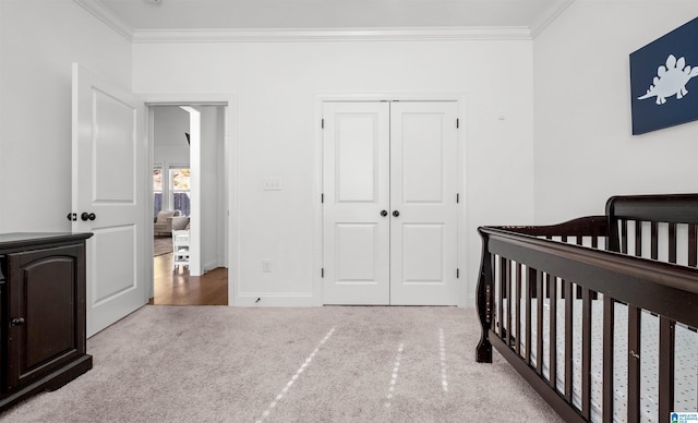 bedroom with a closet, baseboards, a nursery area, and crown molding