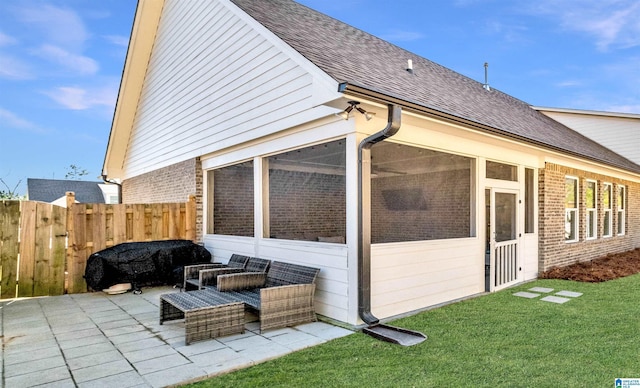 exterior space featuring a patio, fence, roof with shingles, a sunroom, and brick siding