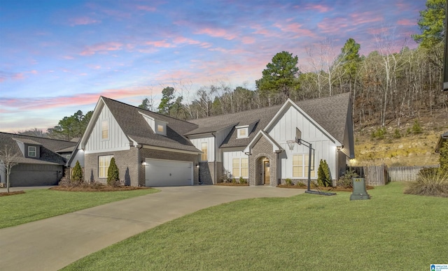 view of front of property with brick siding, board and batten siding, concrete driveway, and a front lawn