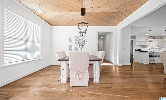 unfurnished dining area featuring light wood-style floors, wooden ceiling, baseboards, a chandelier, and vaulted ceiling