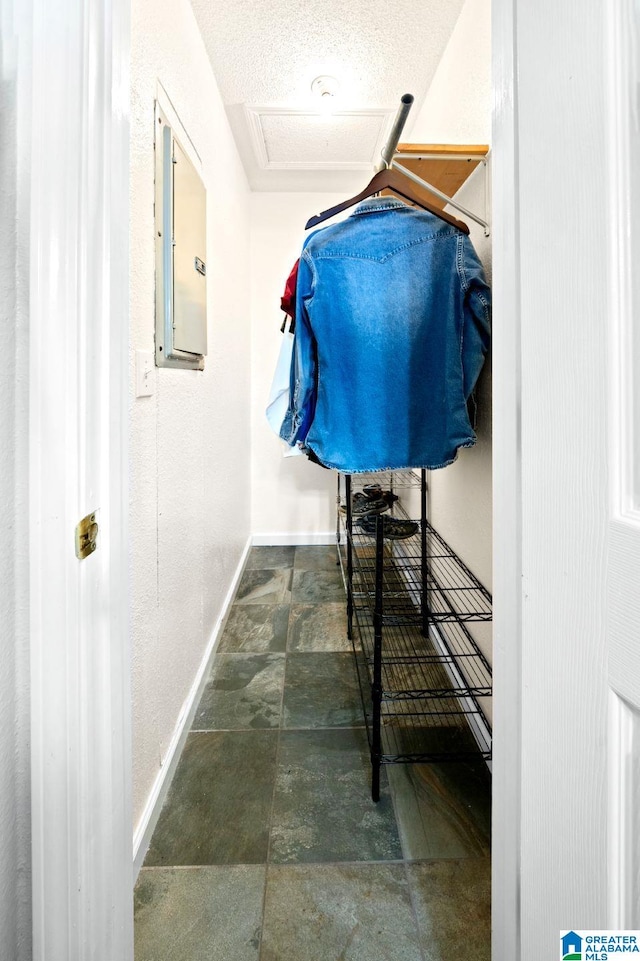 walk in closet with stone finish flooring and electric panel