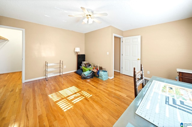 office area with ceiling fan, baseboards, and wood finished floors