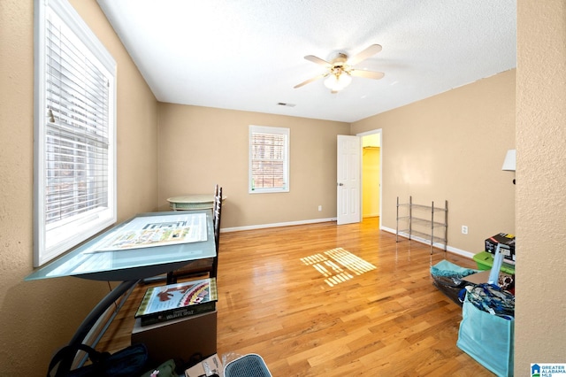 bedroom featuring multiple windows, baseboards, and wood finished floors