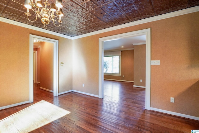 spare room featuring ornamental molding, wood finished floors, an ornate ceiling, and baseboards