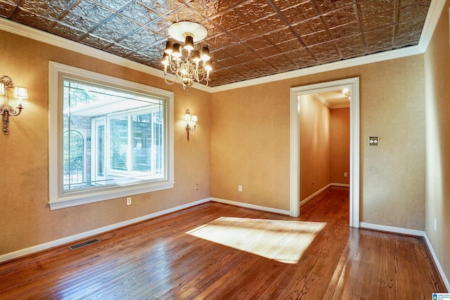 spare room featuring a notable chandelier, visible vents, baseboards, ornamental molding, and an ornate ceiling